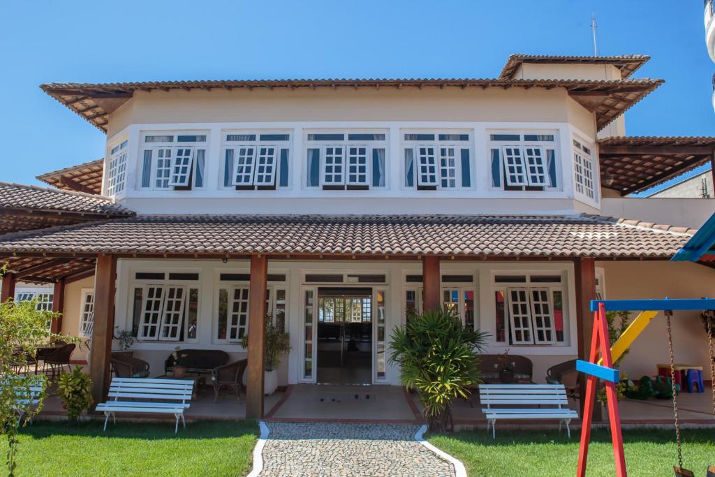 a house with a playground in front of it at Hotel Nova Guarapari in Guarapari