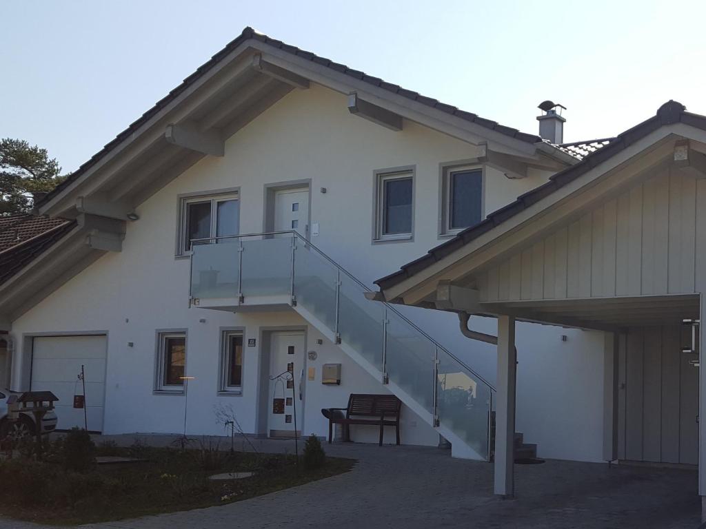 une maison blanche avec un escalier sur son côté dans l'établissement Ferienwohnung Hoherting, à Prien am Chiemsee