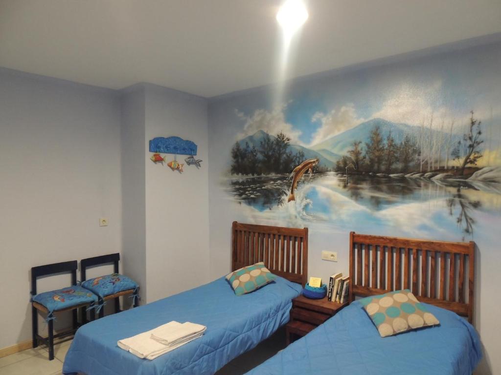 - 2 lits dans une chambre ornée d'une peinture murale dans l'établissement Hostal Can Massot, à Anglès