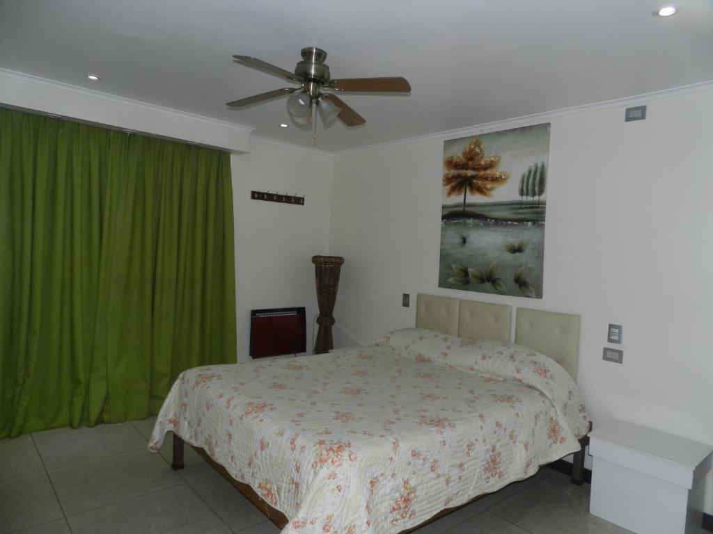 Schlafzimmer mit einem Bett und einem Deckenventilator in der Unterkunft Hotel Guayaquil in Santiago