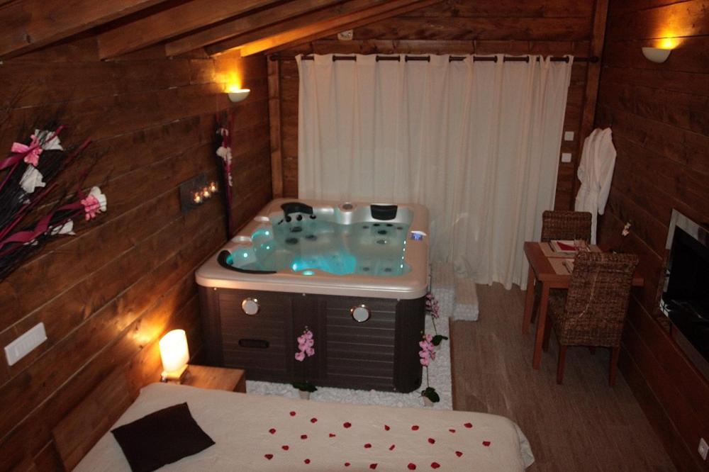 a bathroom with a tub in the middle of a room at La Paillote Exotique Spa in Beaucaire