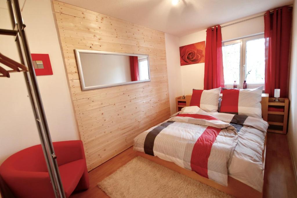1 dormitorio con 1 cama y TV en la pared en Ferienwohnung Döllinger Messe Fränkisches Seenland, en Schwabach