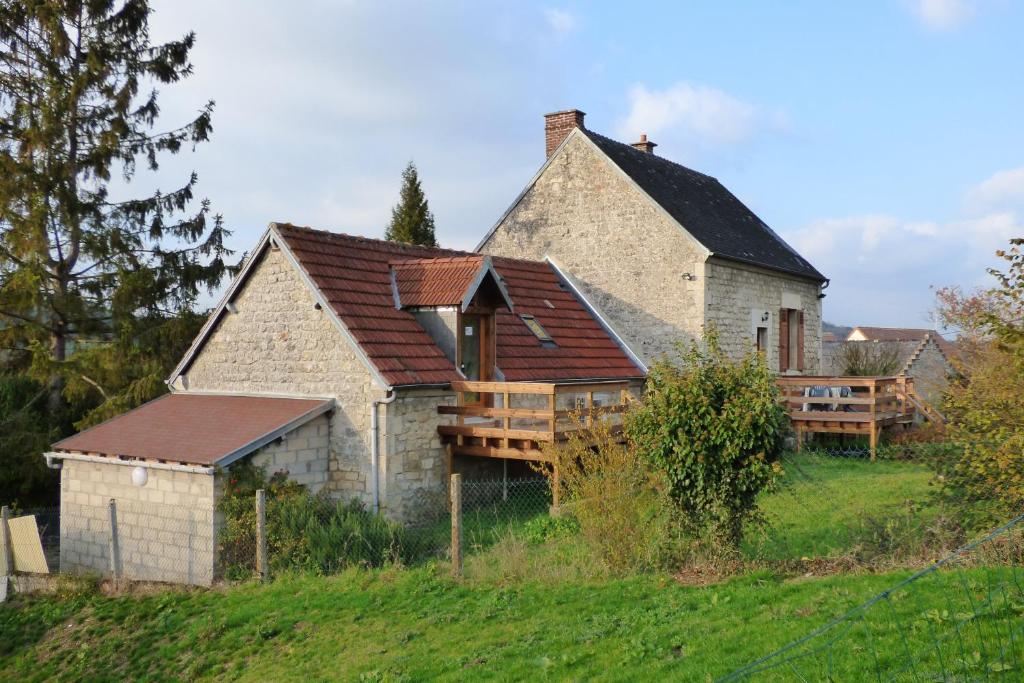 uma casa velha com um deque numa colina em Le Clos du Val em Chivres-Val