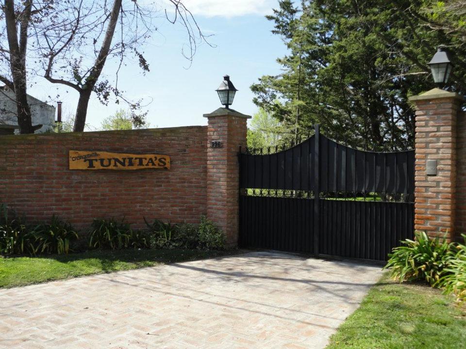 a brick fence with a sign that reads tunias at Cabañas Tunita´s in Coronel Suárez