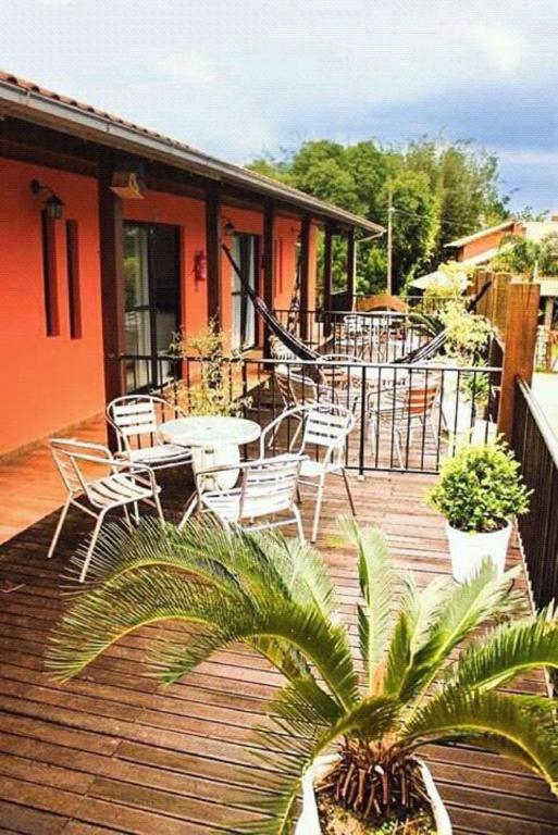 a wooden deck with chairs and tables on a house at Pousada da Guarda in Guarda do Embaú
