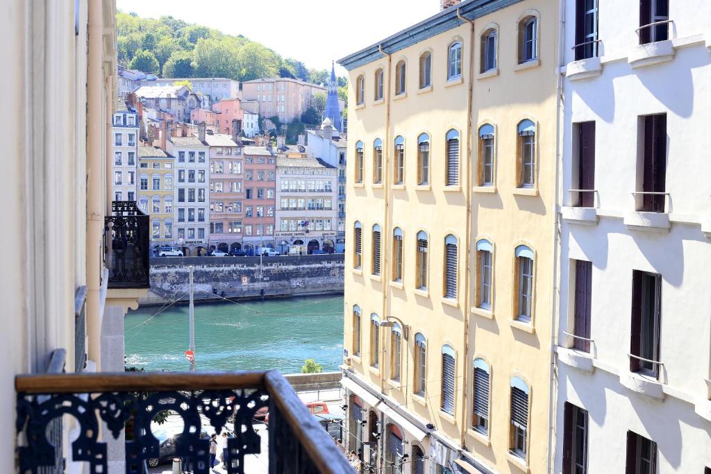 uma vista para um rio a partir de uma varanda com edifícios em La Suite Terreaux em Lyon