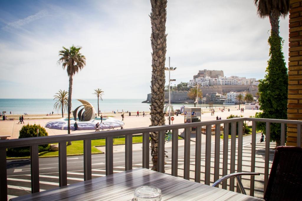 佩尼伊斯科拉的住宿－里奧瑪爾酒店，阳台配有桌子,享有海滩美景