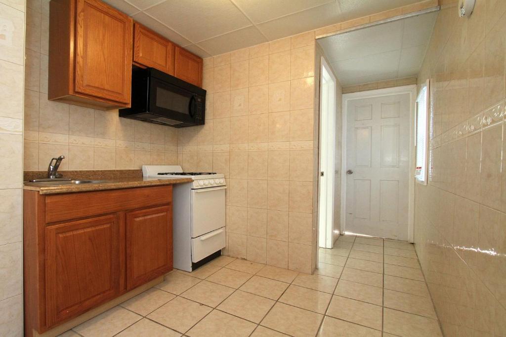 a small kitchen with a stove and a microwave at Shore Beach Houses - 43A Lincoln Ave in Seaside Heights