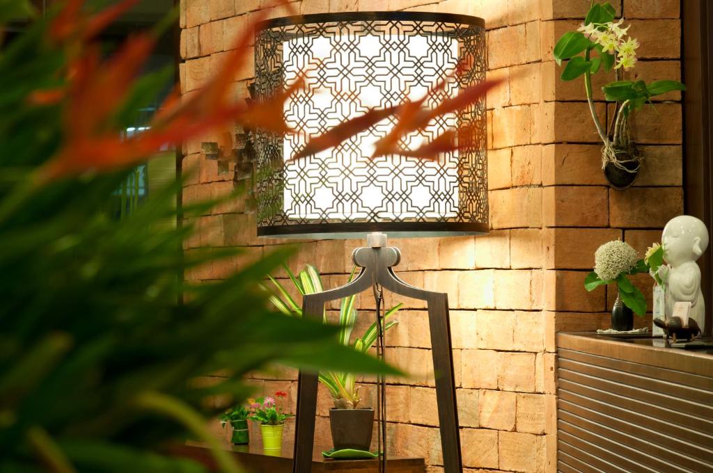 a lamp on a table next to a brick wall at Kasemsarn Hotel Chanthaburi in Chanthaburi