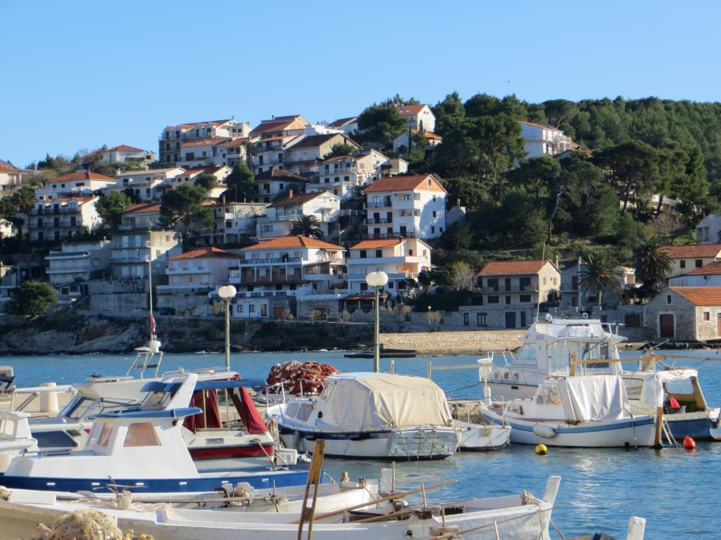 een groep boten aangemeerd in een haven met huizen bij Apartments Makjanić in Jelsa