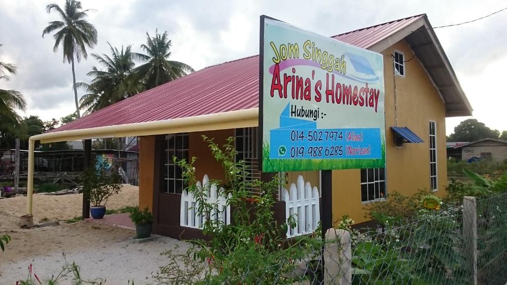 a small yellow building with a sign in front of it at Arina`s Homestay in Kampung Kuala Besut