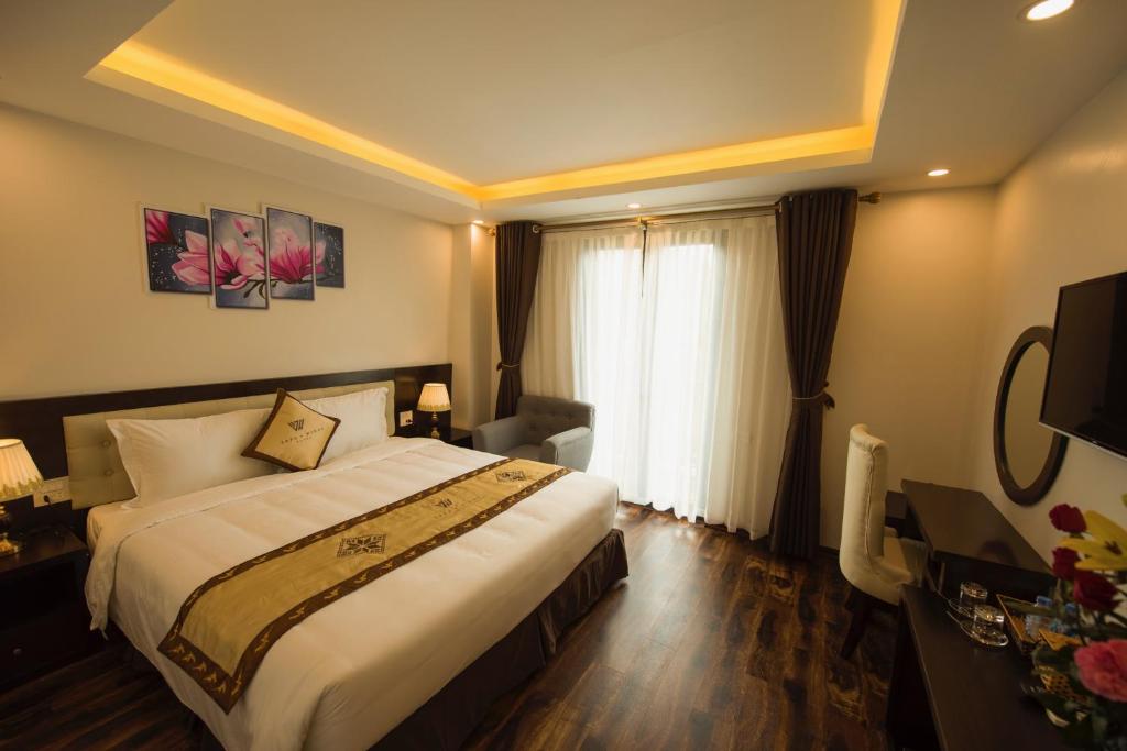 a hotel room with a large bed and a window at Sapa Wings Hotel in Sapa