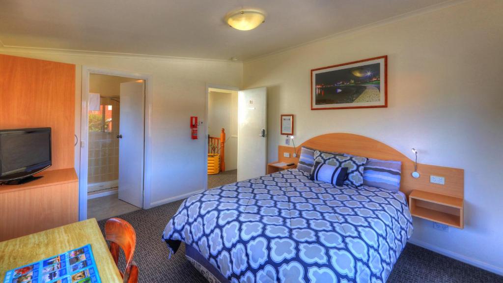 
a bedroom with a bed and a television at Dannebrog Lodge in Devonport
