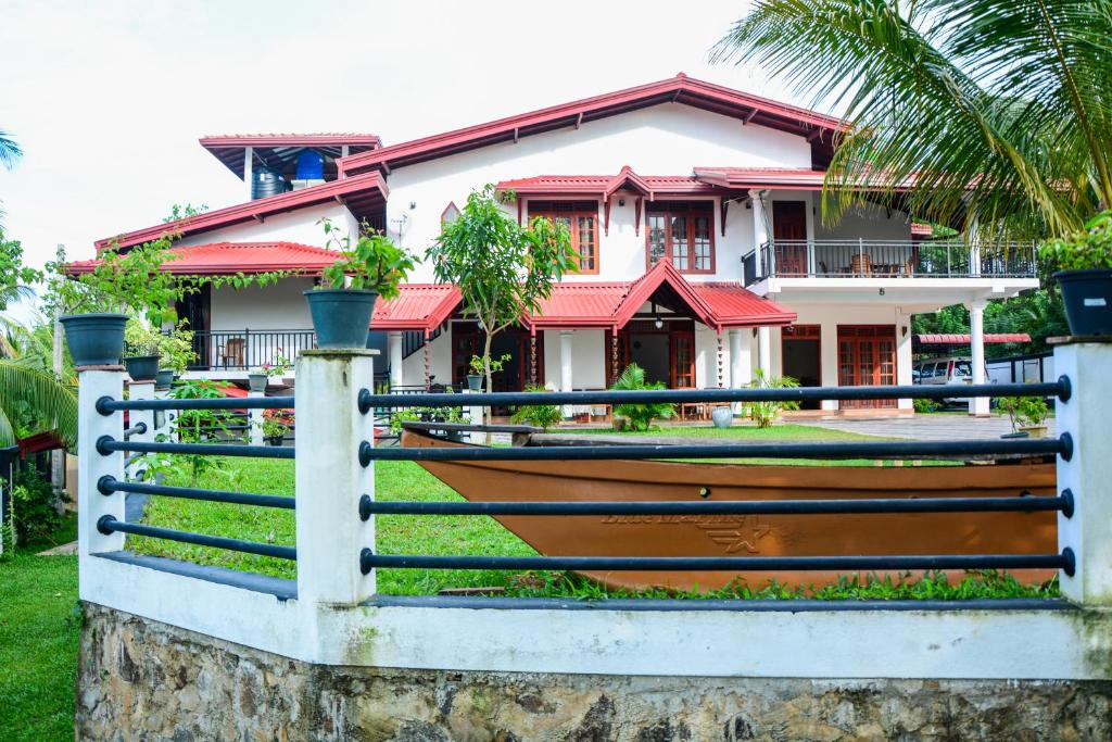 a house with a fence in front of it at Villa Shanaya in Hikkaduwa
