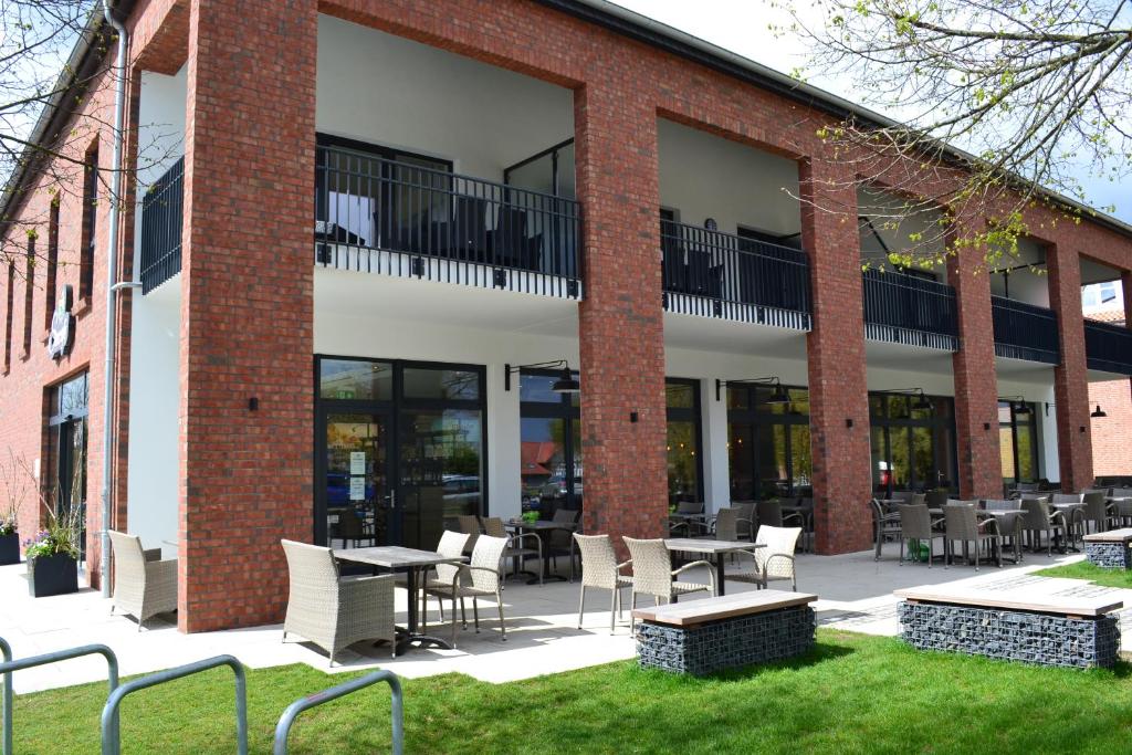 Pension Seecafé في Zarrentin: مبنى به طاولات وكراسي في الفناء