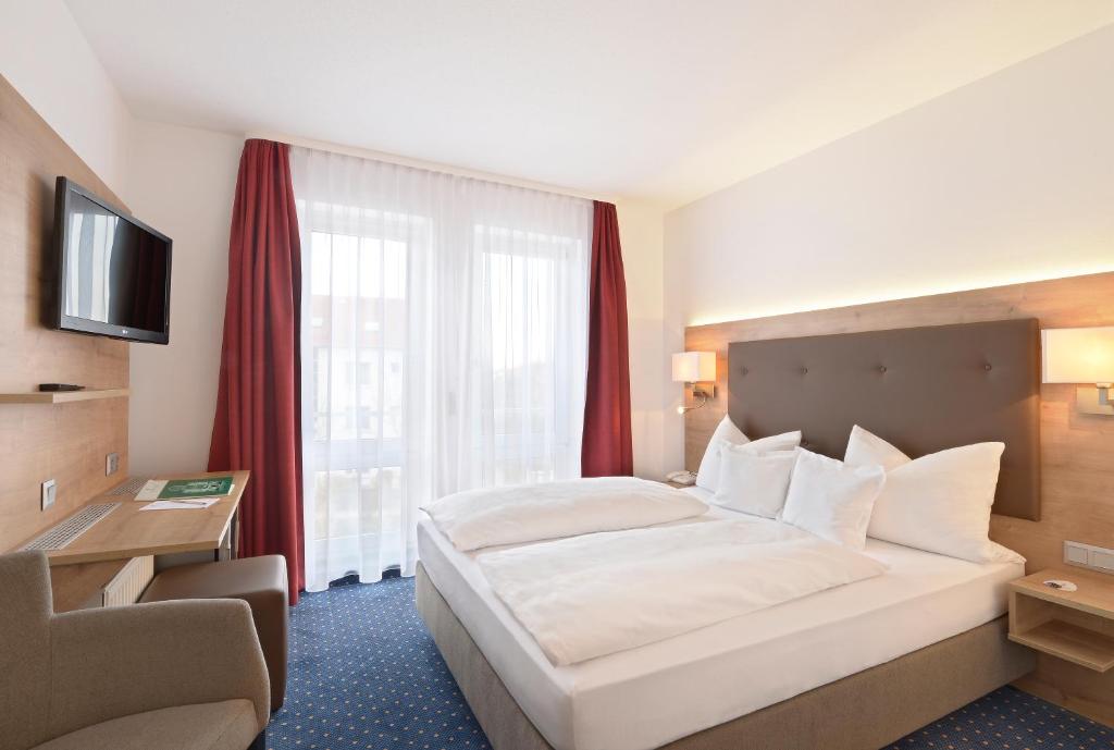 
Ein Bett oder Betten in einem Zimmer der Unterkunft Hotel Poinger Hof
