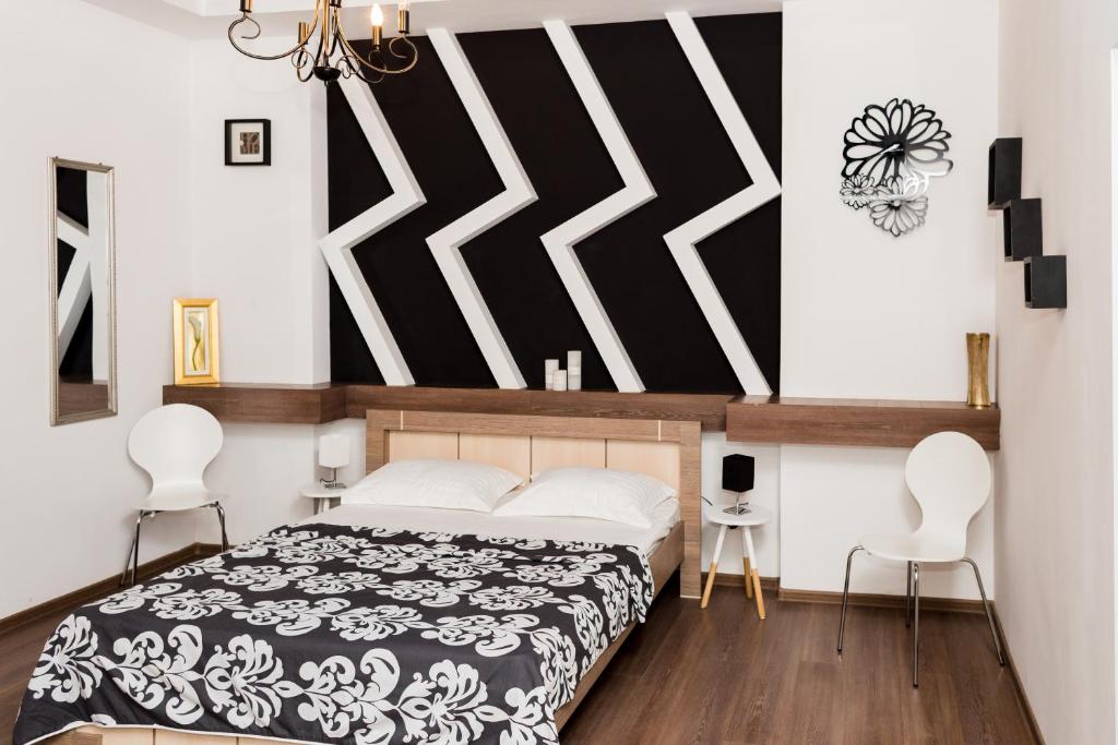 - une chambre avec un lit et deux chaises blanches dans l'établissement Apartments Zefir, à Lviv
