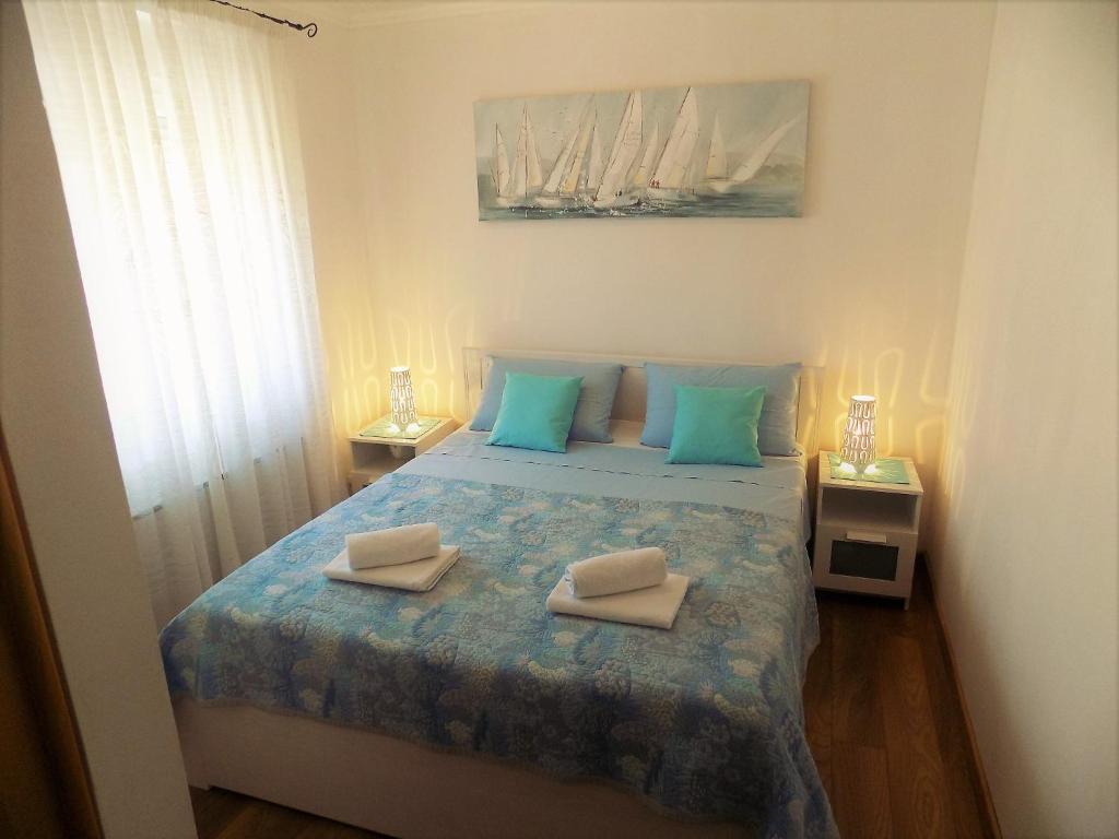 a bedroom with a bed with two towels on it at Apartment Anamarija in Njivice