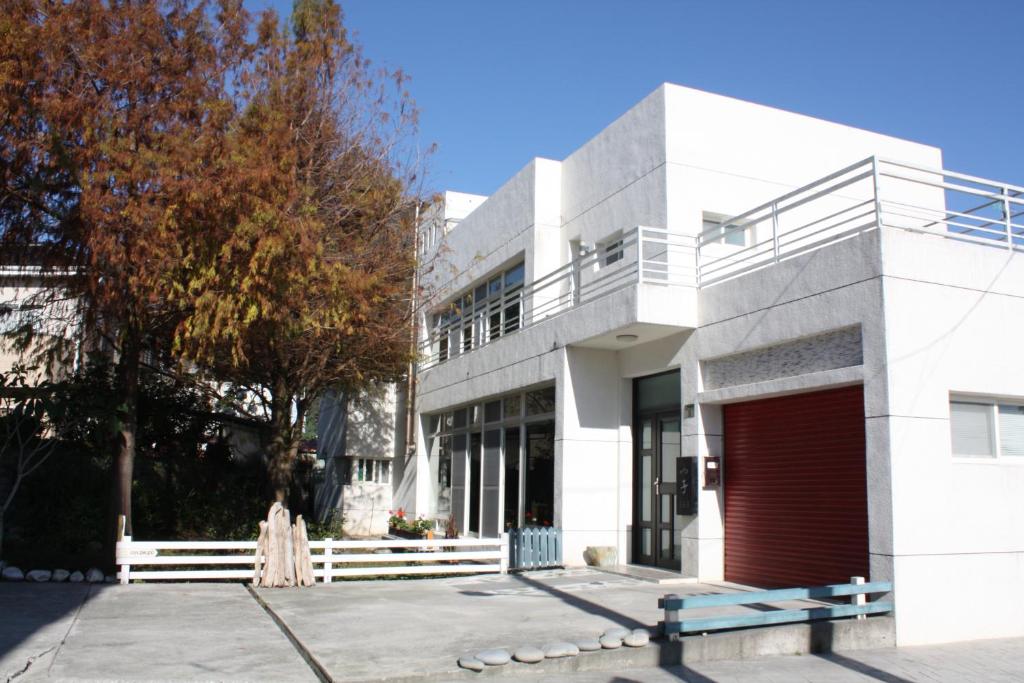 um edifício branco com uma porta vermelha em Katsu B&B em Jian