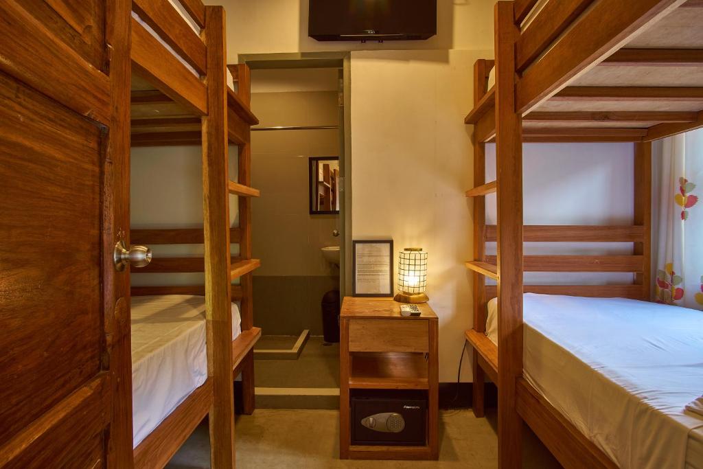 a bedroom with two bunk beds and a tv at Amakan - El Nido Palawan in El Nido