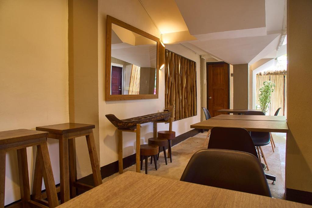 a waiting room with tables and chairs and a mirror at Amakan - El Nido Palawan in El Nido