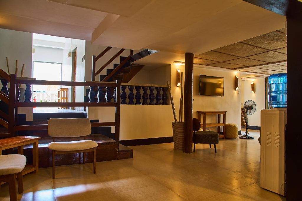 a living room with a staircase and chairs at Amakan - El Nido Palawan in El Nido