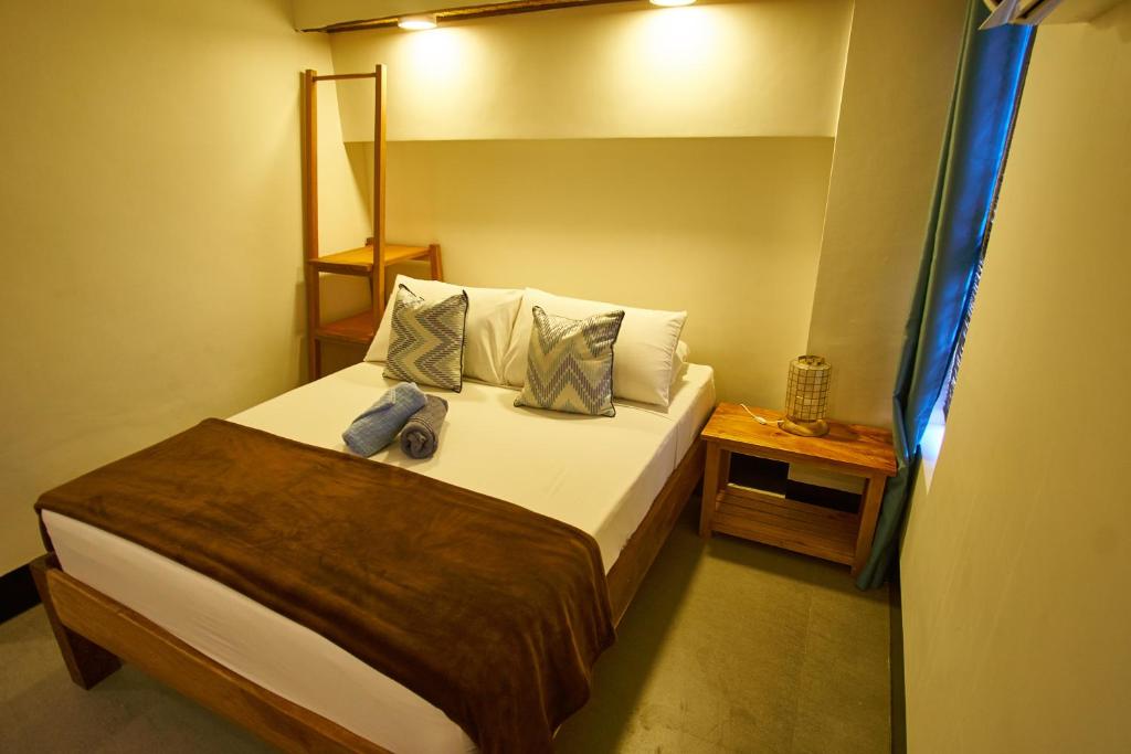 a small bedroom with a bed with two pillows at Amakan - El Nido Palawan in El Nido