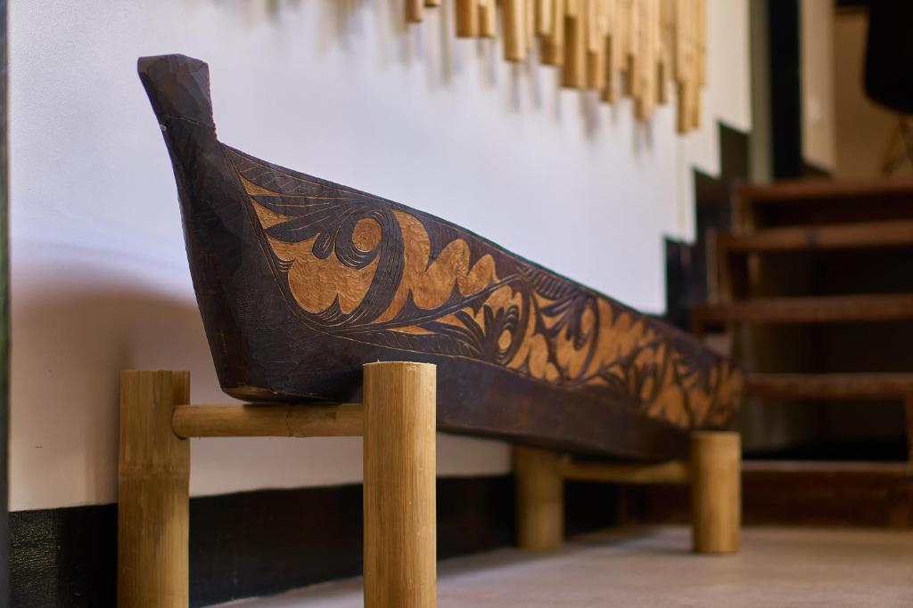 a wooden bench with a design on the back at Amakan - El Nido Palawan in El Nido