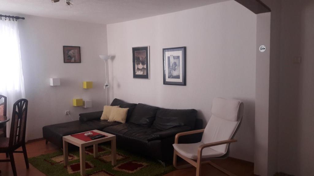 sala de estar con sofá negro y mesa en Apartment VASSA en Kotor
