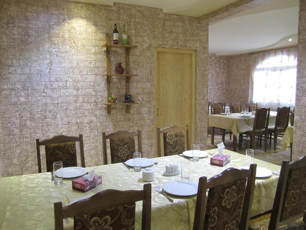 una sala da pranzo con tavoli, sedie e un muro di mattoni di B&B Byurakan-Vanush a Byurakan