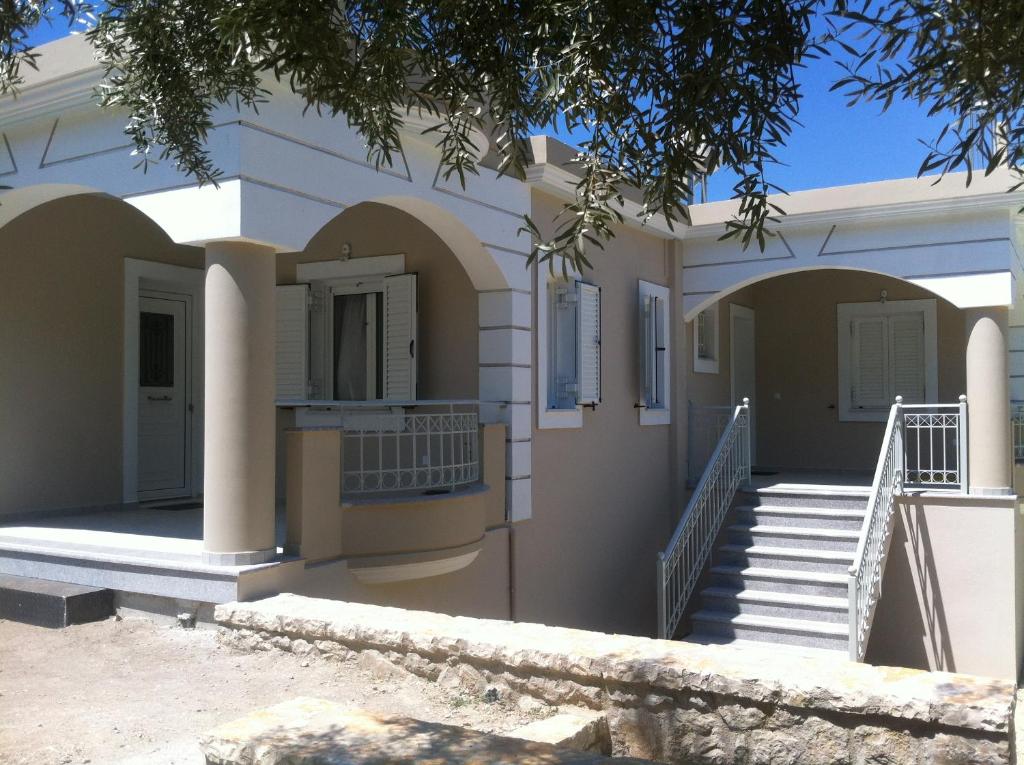 une maison avec des arches et des escaliers devant elle dans l'établissement Kanellos luxury apartments, à Paleros