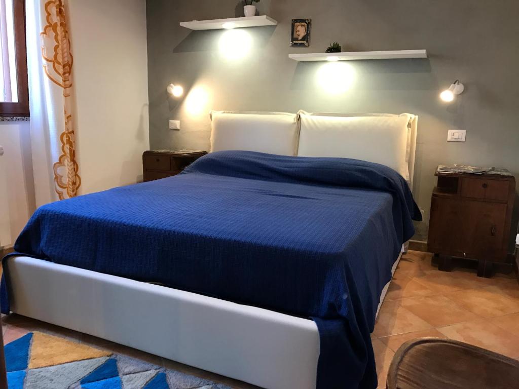 een slaapkamer met een blauw bed met witte kussens bij Casa Vacanze Primacroce in Cefalù