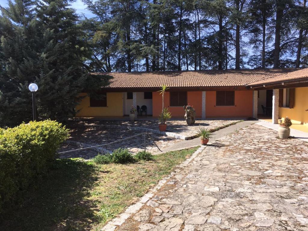 mały żółty dom z kamiennym podjazdem w obiekcie Agriturismo Usurtala w mieście Orani