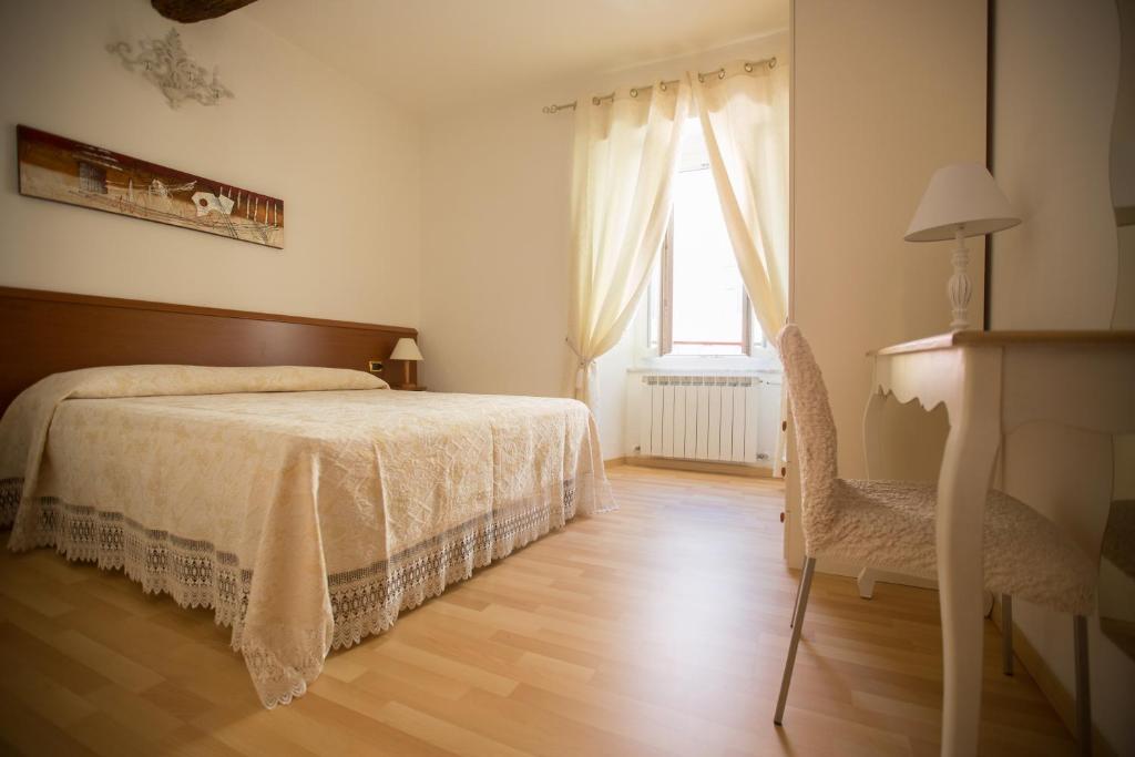 a bedroom with a bed and a chair and a window at Affittacamere Anna Michielini in Riomaggiore