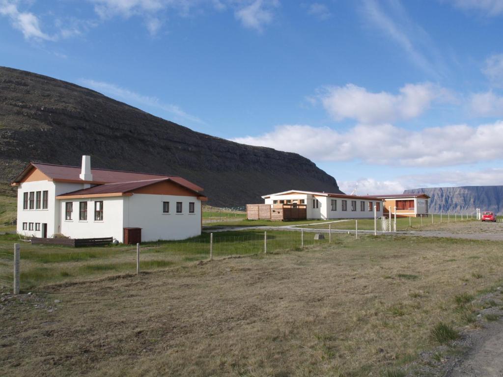 un gruppo di edifici di fronte a una collina di Hotel Latrabjarg a Hnjótur