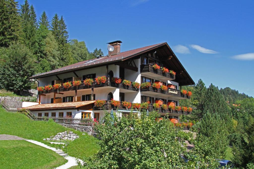 uma casa numa colina com flores em Landhaus Sonnenbichl Mittenwald em Mittenwald