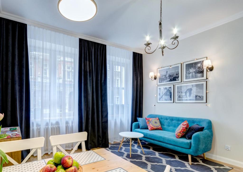 a living room with a blue couch and a table at Balans Old Town in Gdańsk