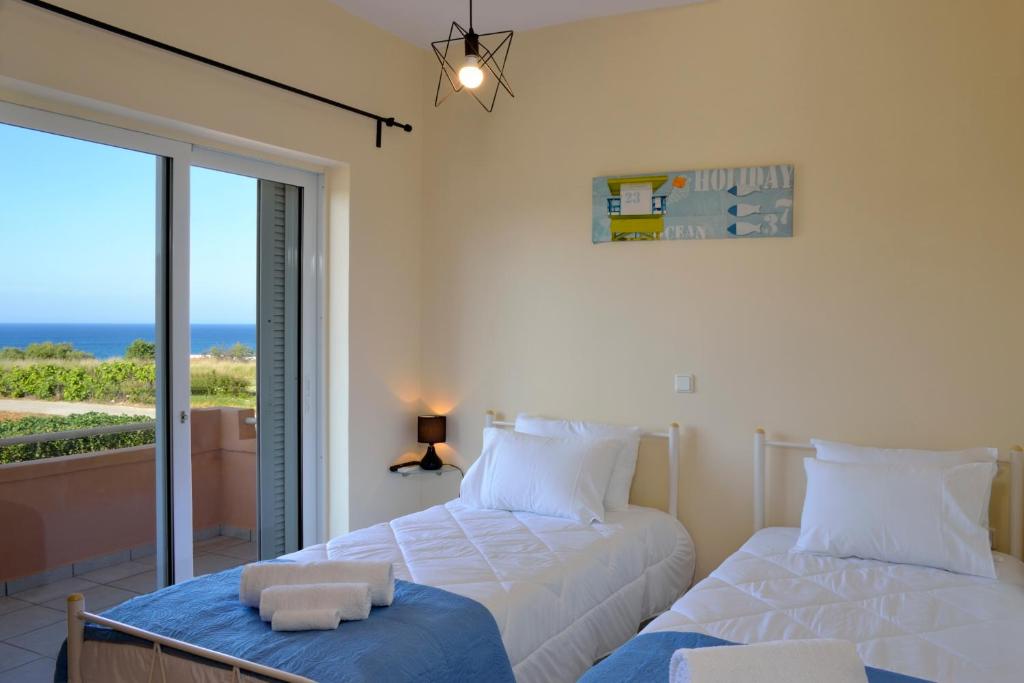スタロスにあるSofoklis Aptsの海の景色を望むベッドルーム1室(ベッド2台付)