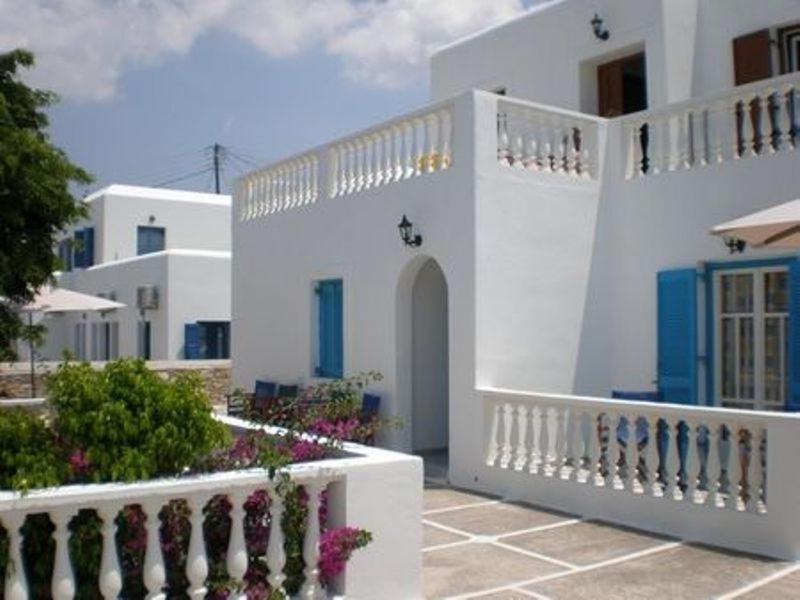 a white house with a white fence and flowers at Artemis Pension in Ios Chora
