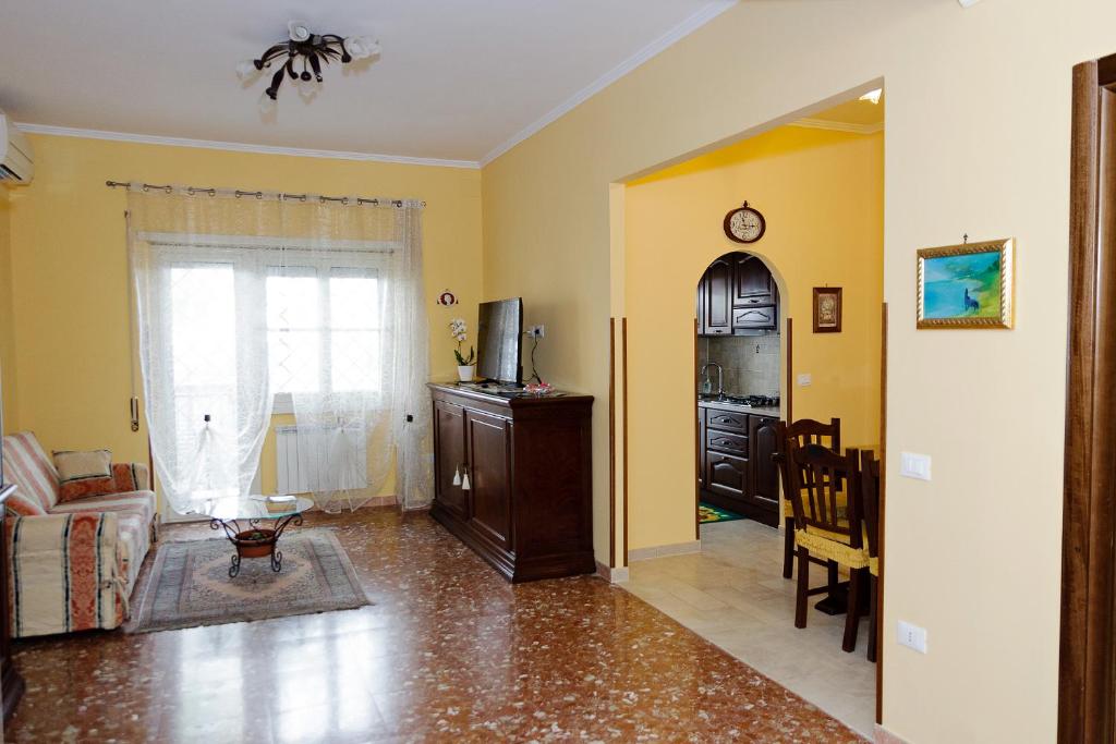 ローマにあるCasa Vacanza Da Andreaの黄色の壁のリビングルーム(テレビ、ソファ付)