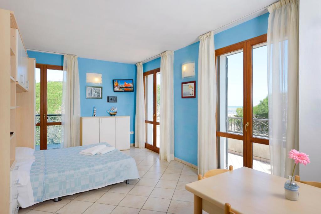 a bedroom with blue walls and a bed and a table at Residence Riva Blu in Cesenatico