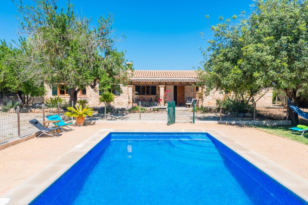 a blue swimming pool in front of a house at Can Rafalino in Inca