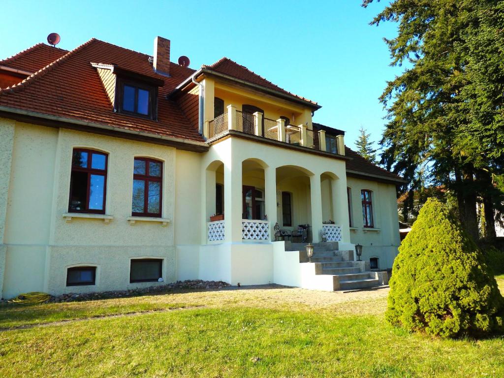 a large house with a roof on a yard at Ferienwohnung Villa am Haussee in Feldberg