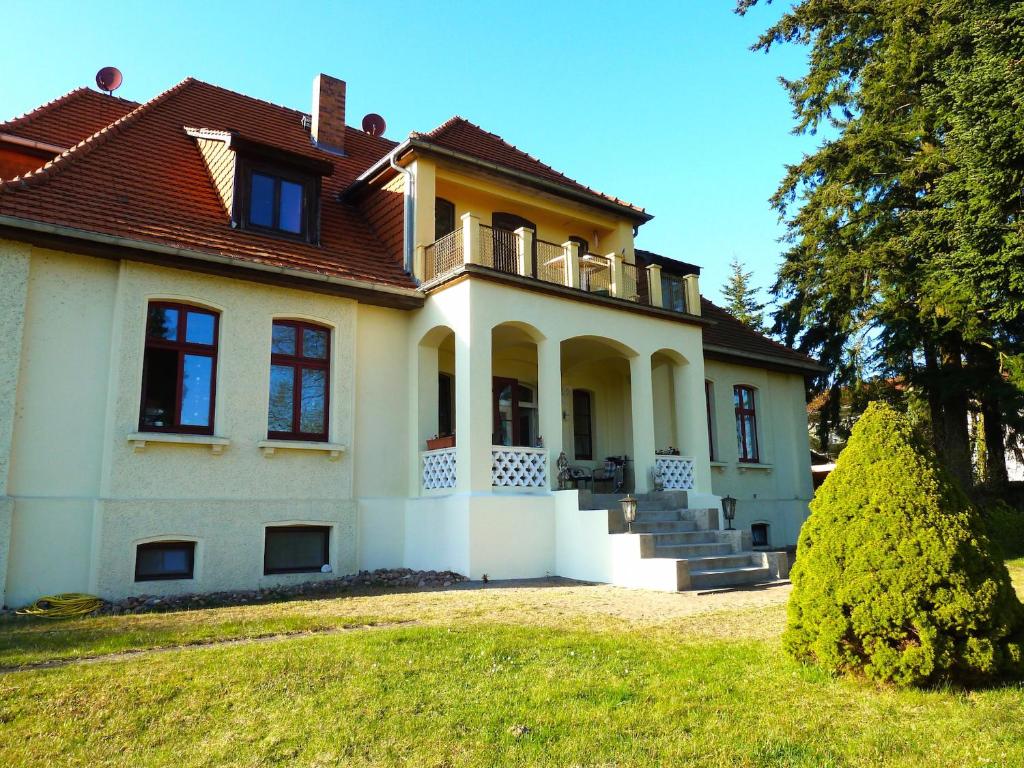 una casa grande con techo en un patio en Ferienwohnung Villa am Haussee, en Feldberg