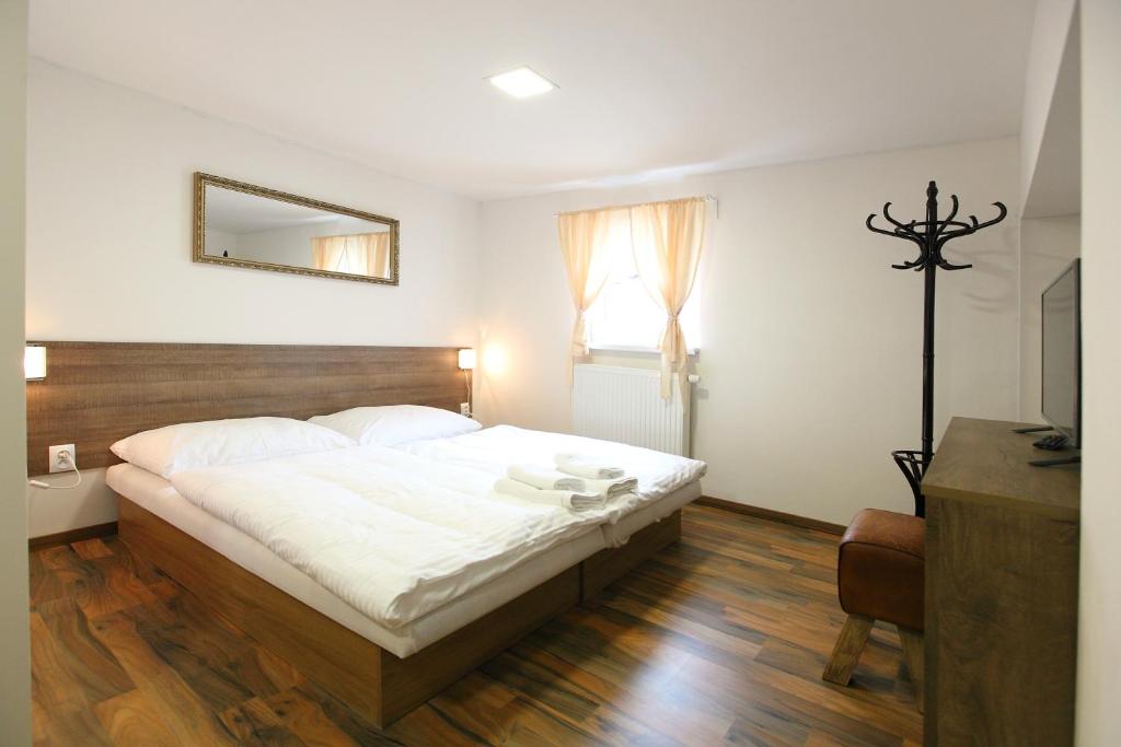 ein Schlafzimmer mit einem großen Bett und einem Spiegel in der Unterkunft Penzión Ulička in Stupava