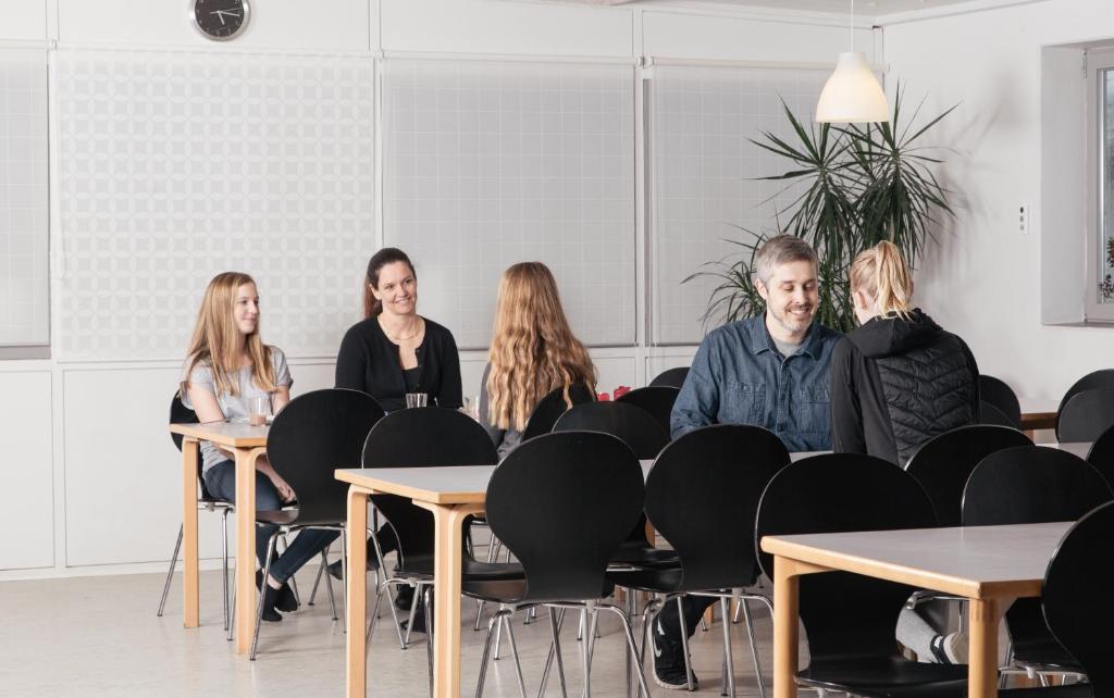 um grupo de pessoas sentadas em mesas em uma sala em Thommysminde em Jelling