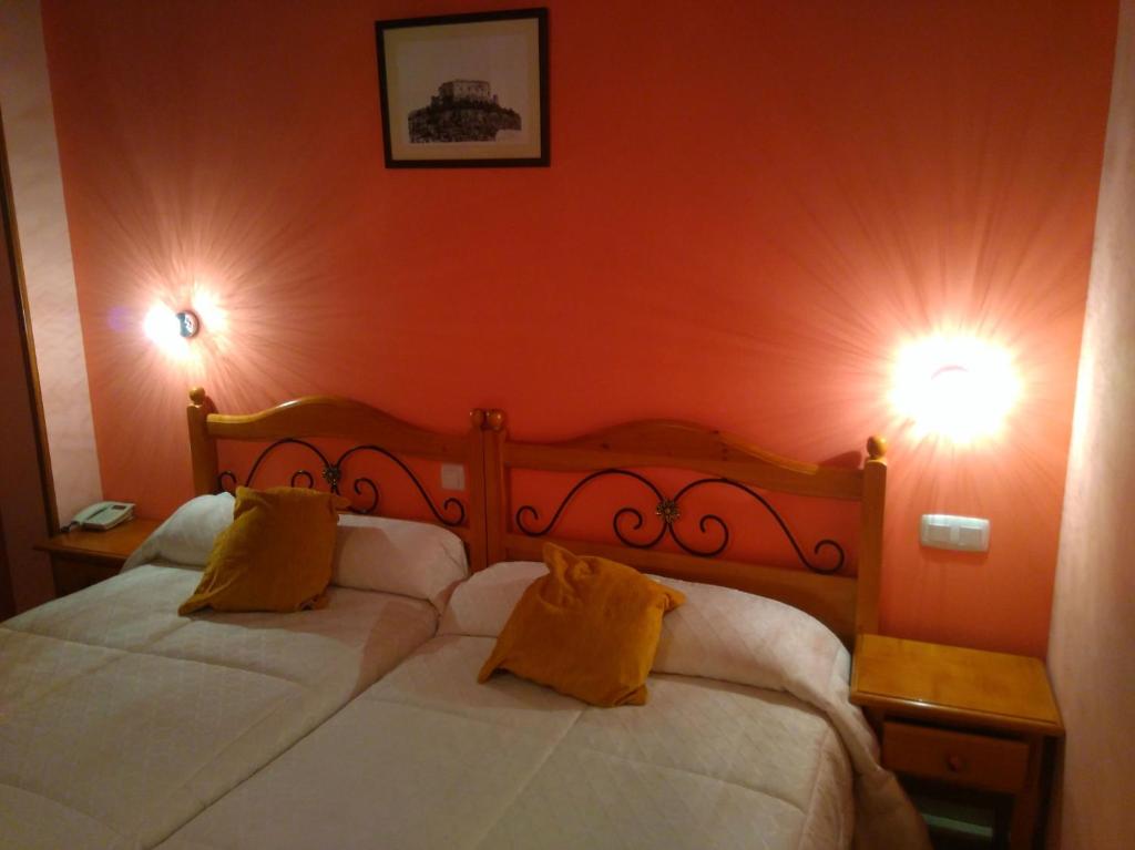 
a bed in a bedroom with a lamp on top of it at San Miguel in Segovia
