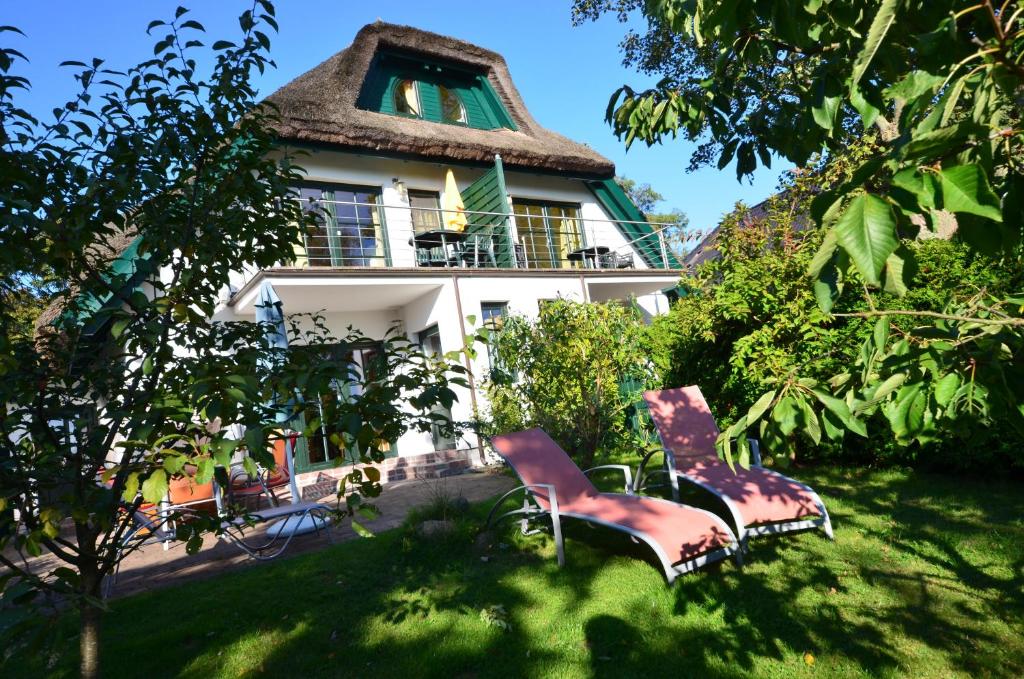 una casa con dos sillas delante en Reethauser Boddenstr. 17, en Gager