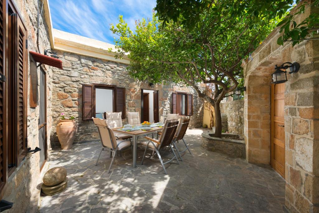 un patio al aire libre con mesa y sillas en Villa Claudia in Lardos en Lardos