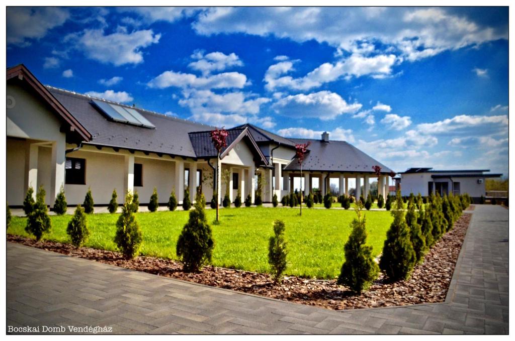 a house with a green lawn in front of it at Bocskai Domb Vendégház in Nagykálló